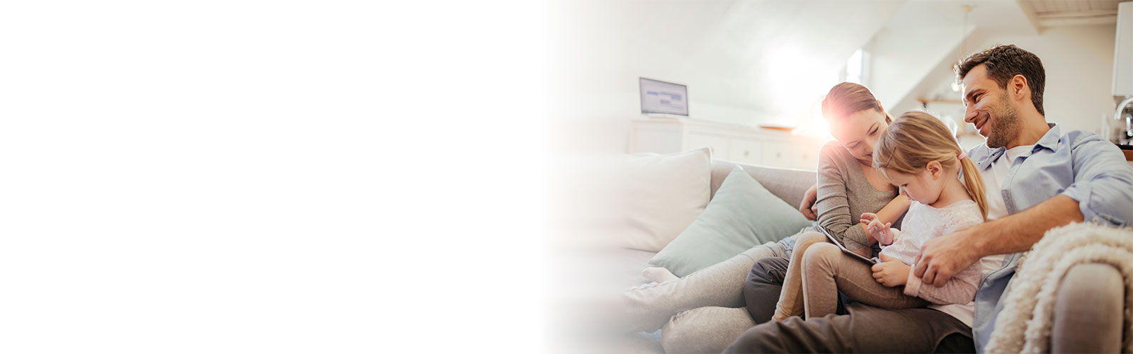 Family on sofa, child playing on tablet