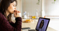 Person sat at a desk using a laptop for an online virtual consultation