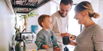 Young family laughing while having breakfast together
