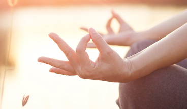 Woman meditating by the lake